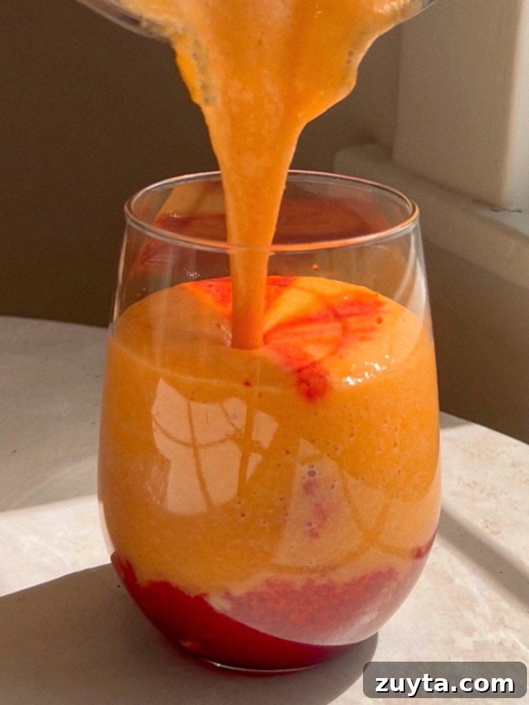 Turmeric Crush Tropical Slushie in a glass with bright tropical colors