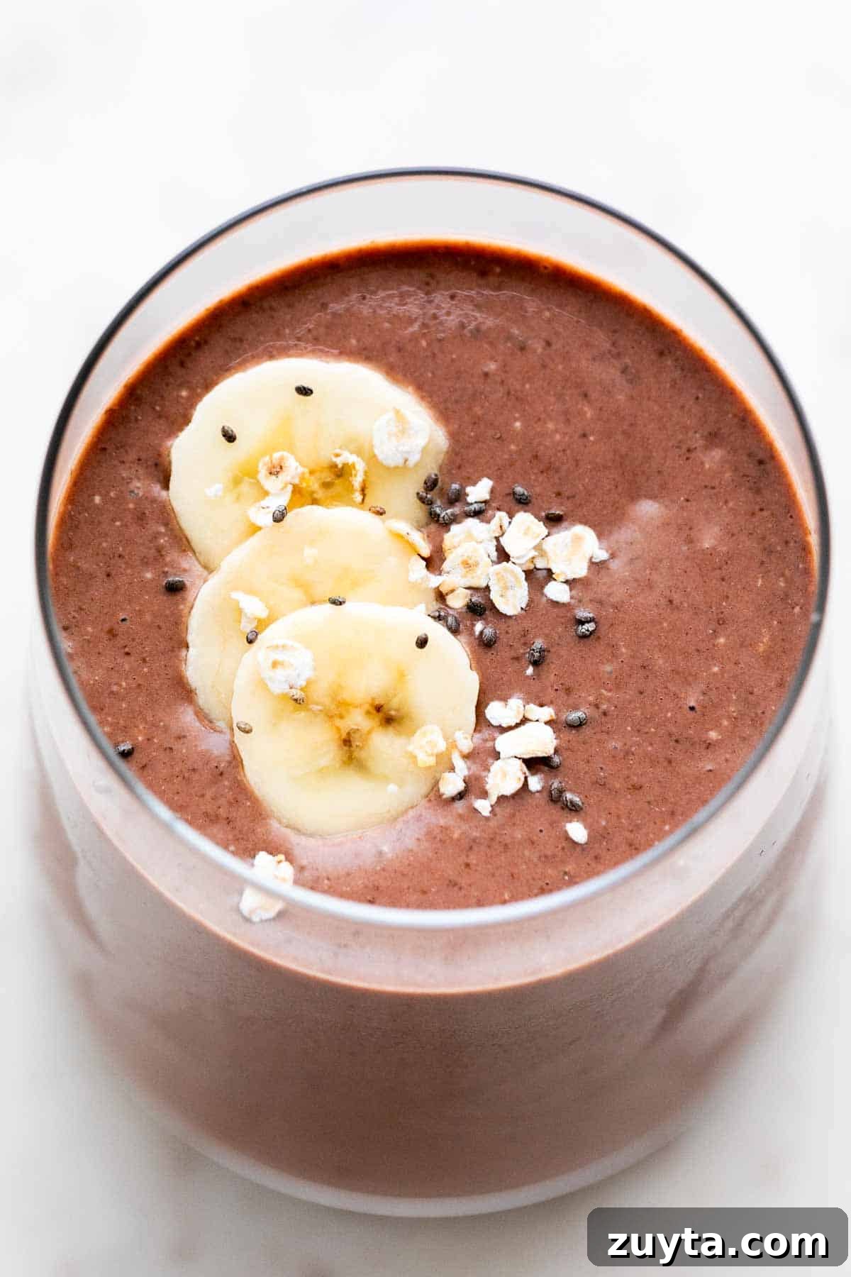 Creamy Vegan Protein Shake Recipe 6 Glass of vegan protein shake garnished with banana, oats, and chia seeds.