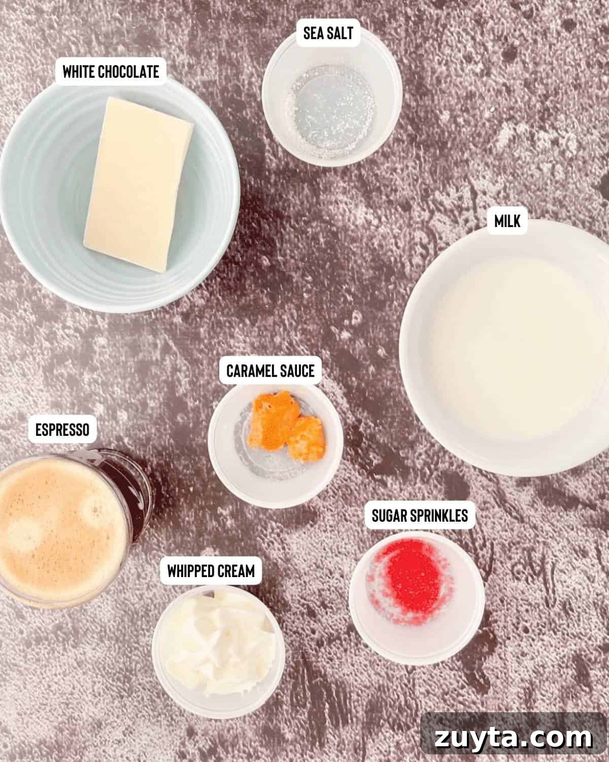 Ingredients for Starbucks toasted mocha measured out and placed on a gray table in measuring cups and bowls