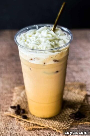 A picture of a Starbucks copycat iced white chocolate mocha in a tall glass.