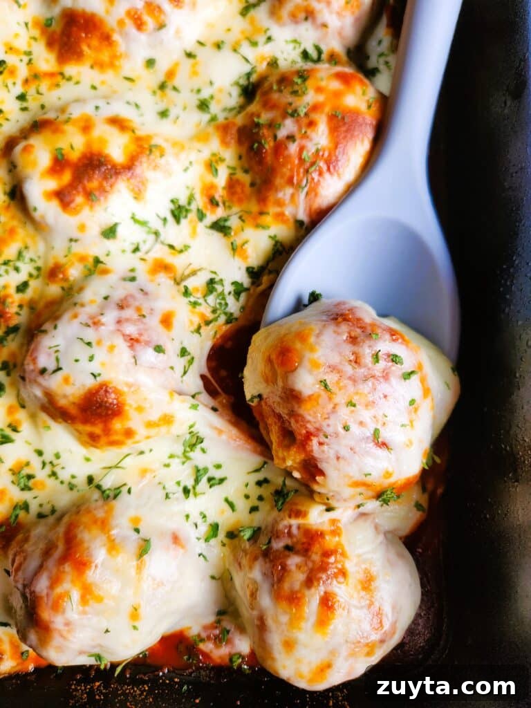 Baked Chicken Meatballs with Mozzarella in Tomato Sauce 2 Baked chicken meatballs in tomato sauce topped with melted mozzarella cheese in a baking dish, perfect for pasta, meatball subs, or meal prep