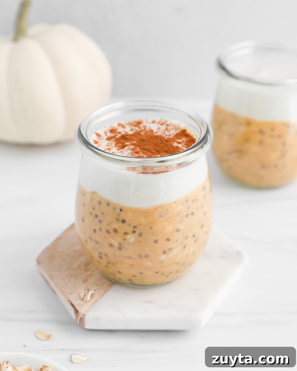 Creamy Pumpkin Pie Overnight Oats Recipe 7 Overnight oats and vanilla yogurt in a glass that is topped with spices.