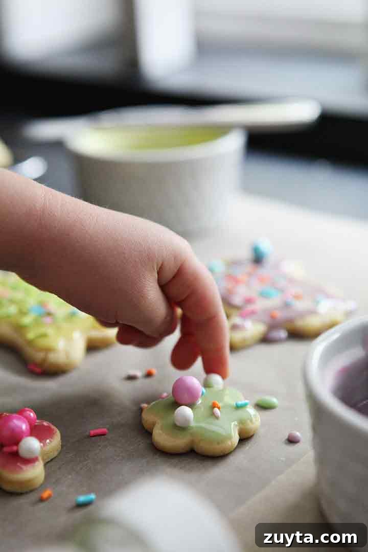 Lemon Tea Cakes Recipe with Zesty Glaze 7 A girl places decorative sprinkles onto lemon sugar cookies