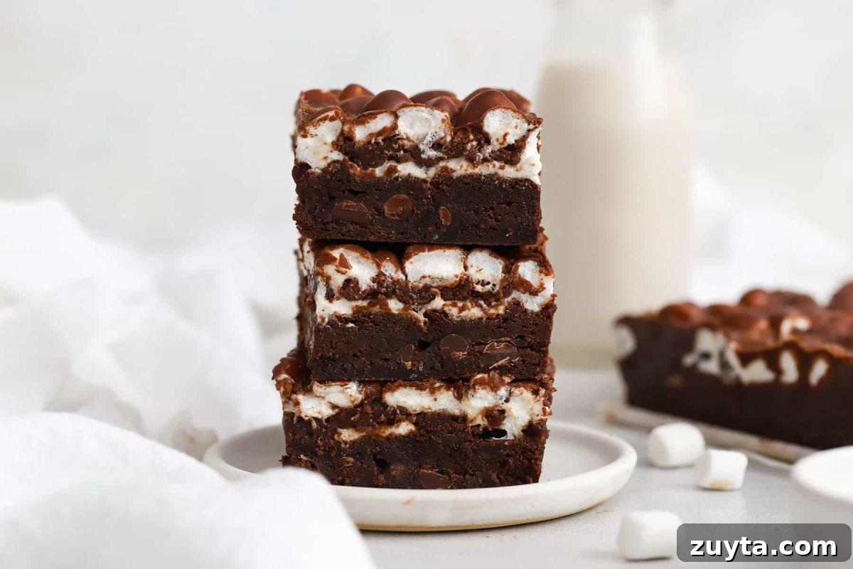 three gluten-free marshmallow brownies stacked on a plate