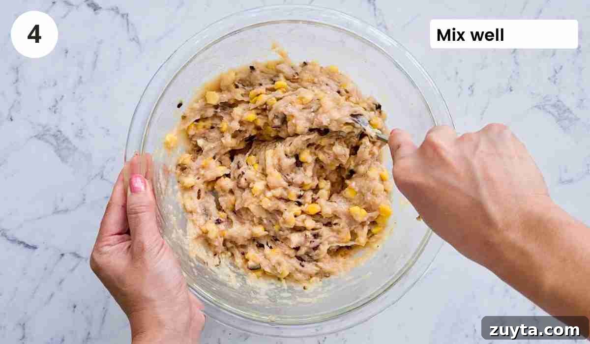 How to Make Authentic Chinese Chicken Dumplings 7 Chicken dumpling filling being mixed with a spoon, in a large bowl with caption