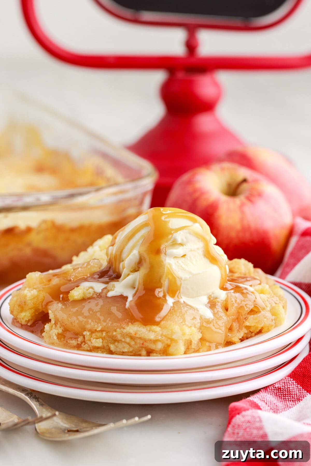 Classic Apple Dump Cake Recipe with Cinnamon 3 Apple Dump Cake on a plate toped with ice cream and caramel