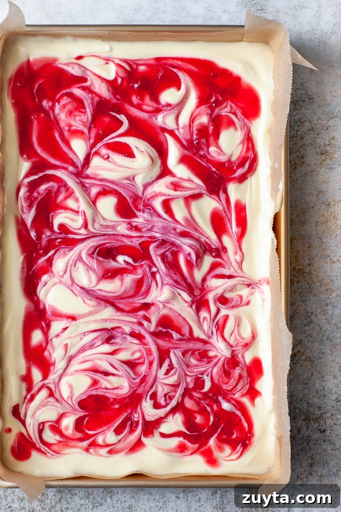 Creamy White Chocolate Raspberry Cheesecake Bars Recipe 7 Swirls of raspberry sauce in cheesecake bars.