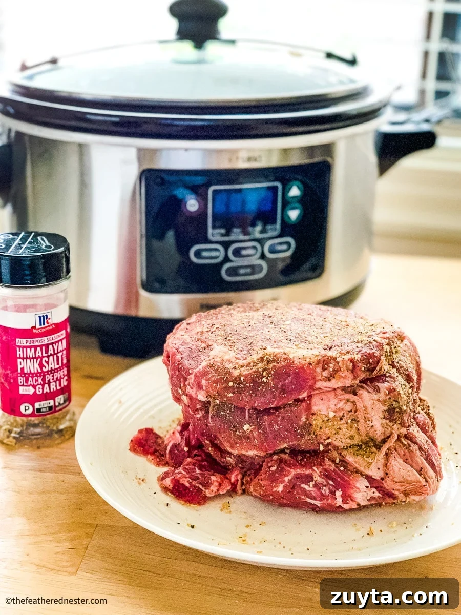 Tender Slow Cooker Shredded Chuck Roast Recipe 4 seasoned beef roast with a crock pot and seasoning.