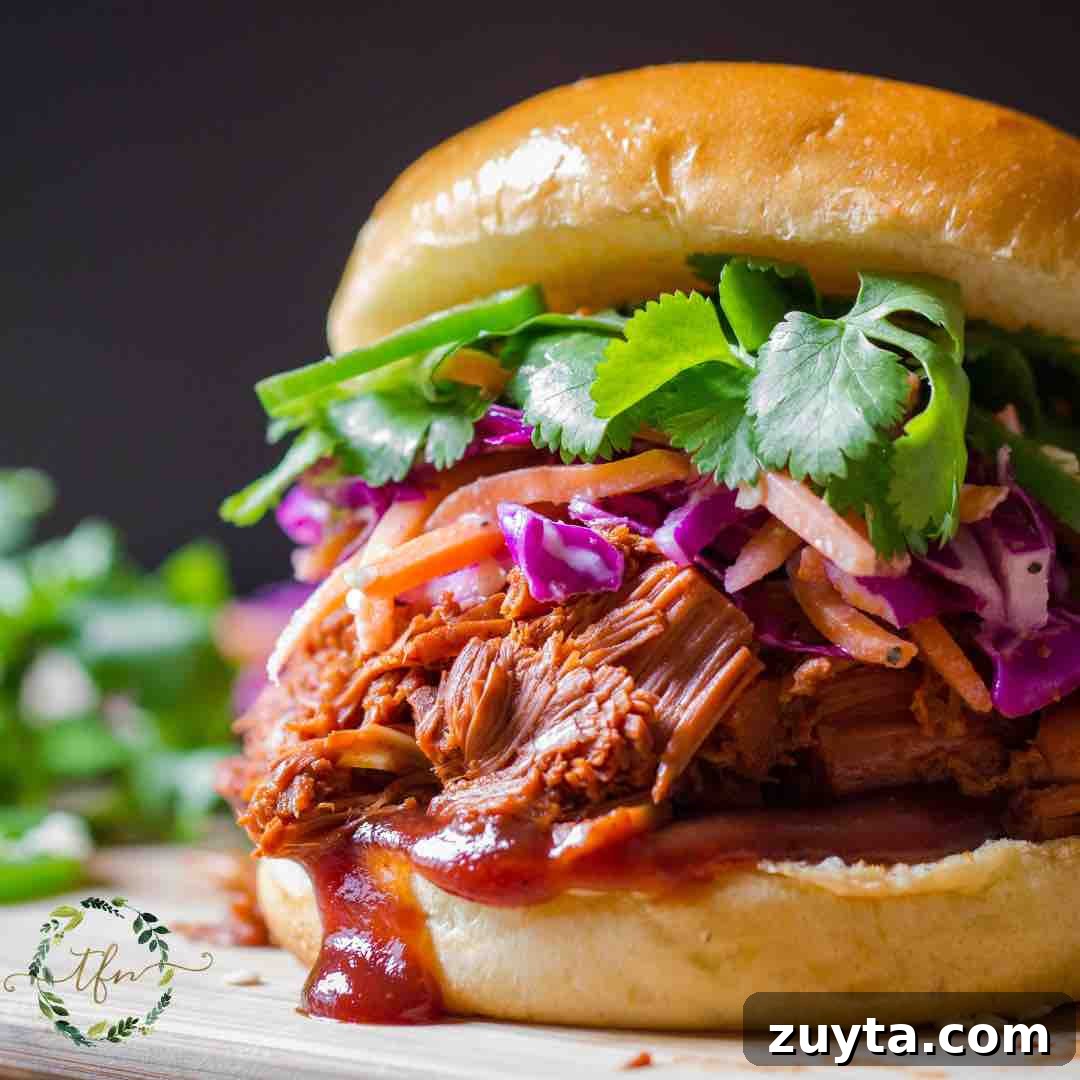Tender Slow Cooker Shredded Chuck Roast Recipe 6 BBQ Pulled Beef on a roll.