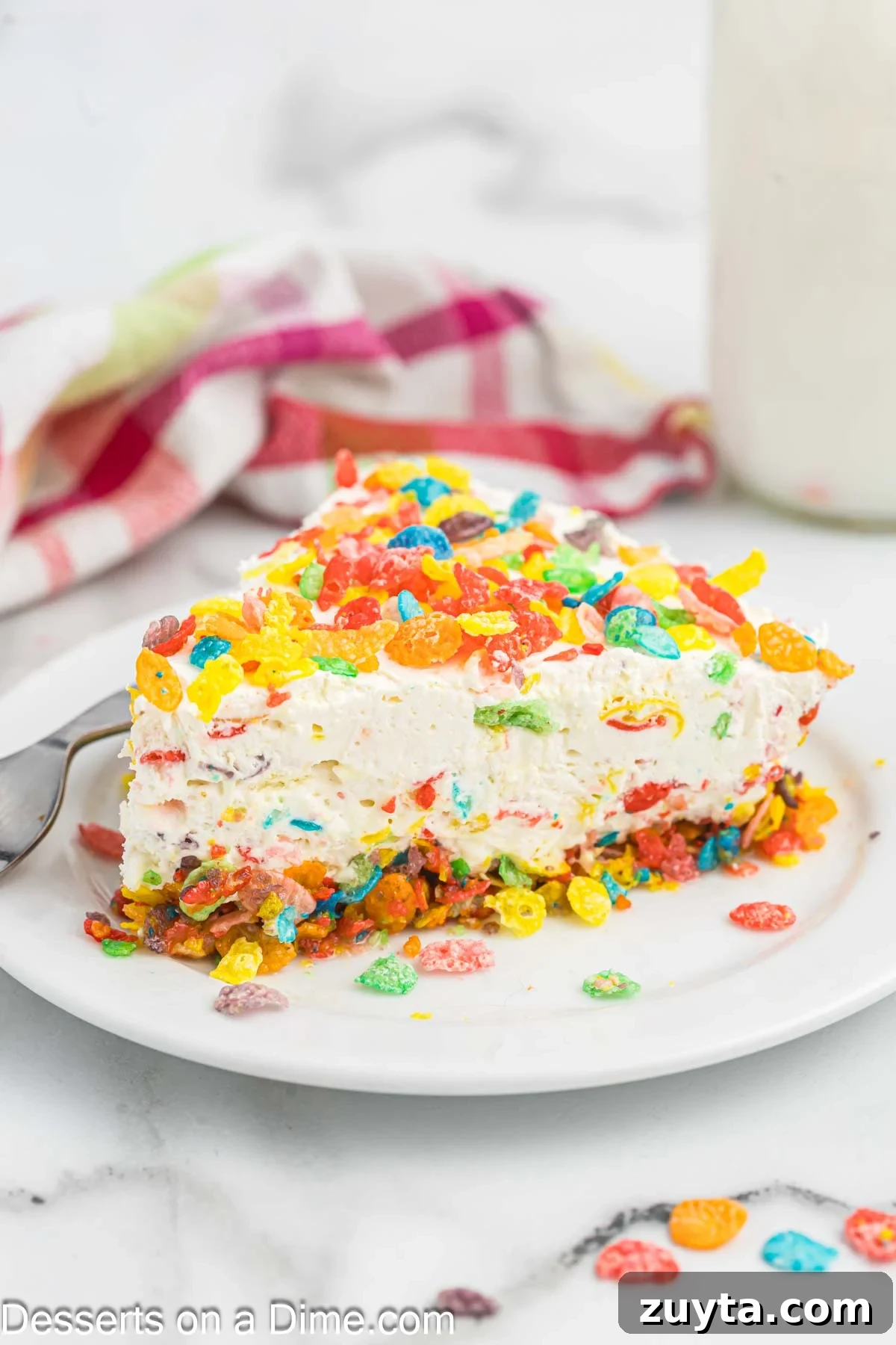 Fruity Pebbles Cheesecake Recipe with Rainbow Cereal Topping 2 Slice of Fruity Pebbles Cheesecake on a plate.