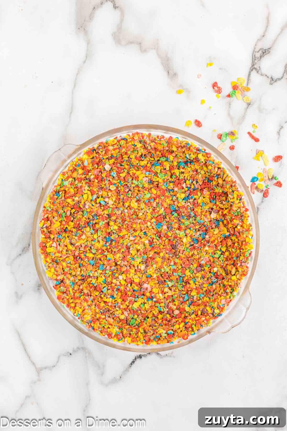 Fruity Pebbles Cheesecake Recipe with Rainbow Cereal Topping 5 Cereal combined with melted butter and pressed into pan.