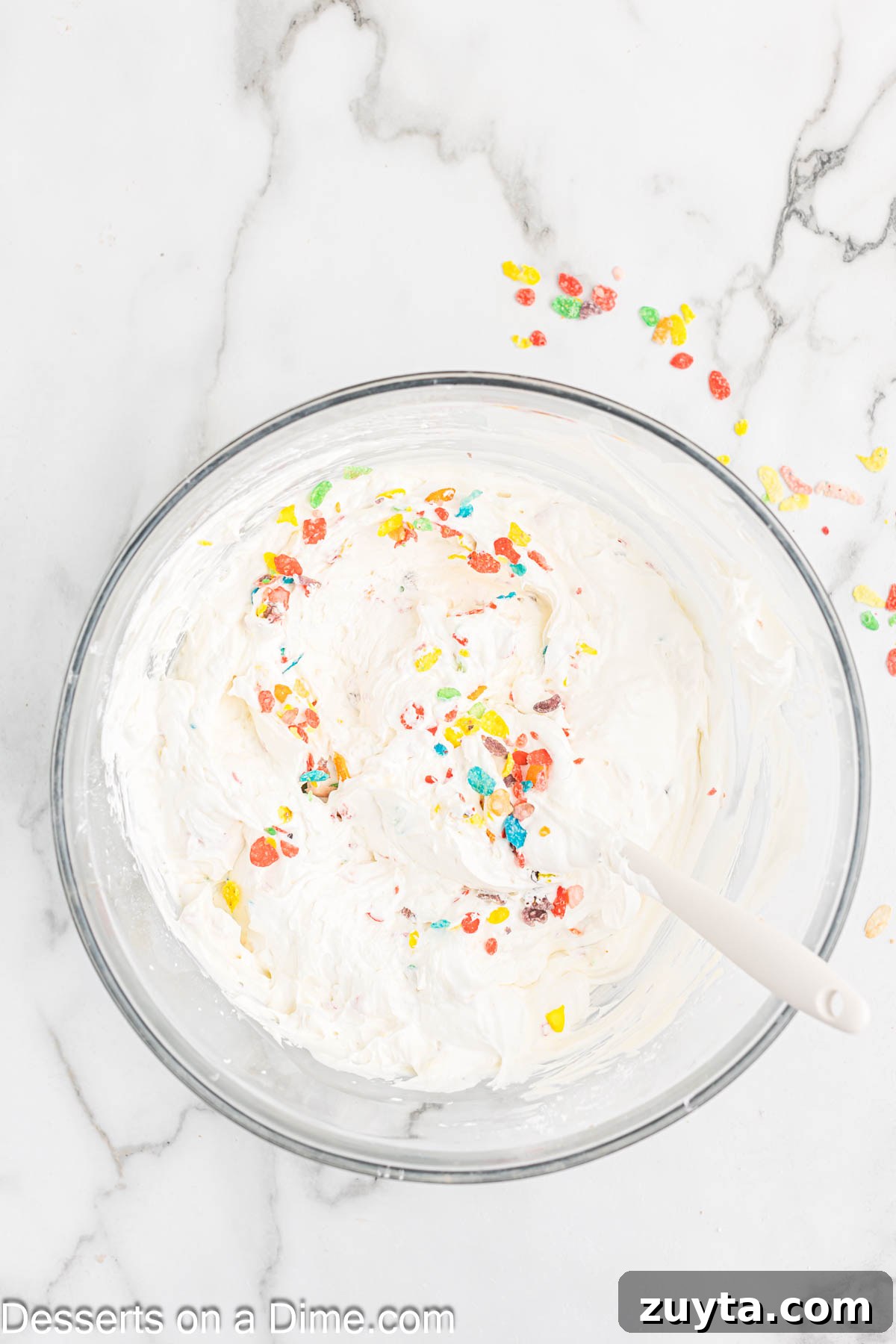 Fruity Pebbles Cheesecake Recipe with Rainbow Cereal Topping 7 Cool whip and cereal folded into mixture.