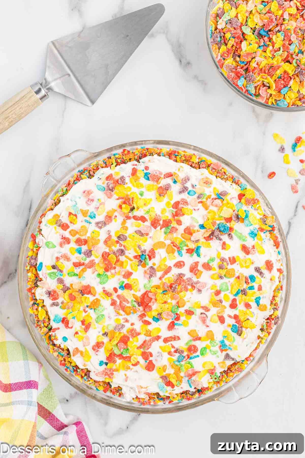 Fruity Pebbles Cheesecake Recipe with Rainbow Cereal Topping 9 More cereal sprinkled on top of cheesecake.