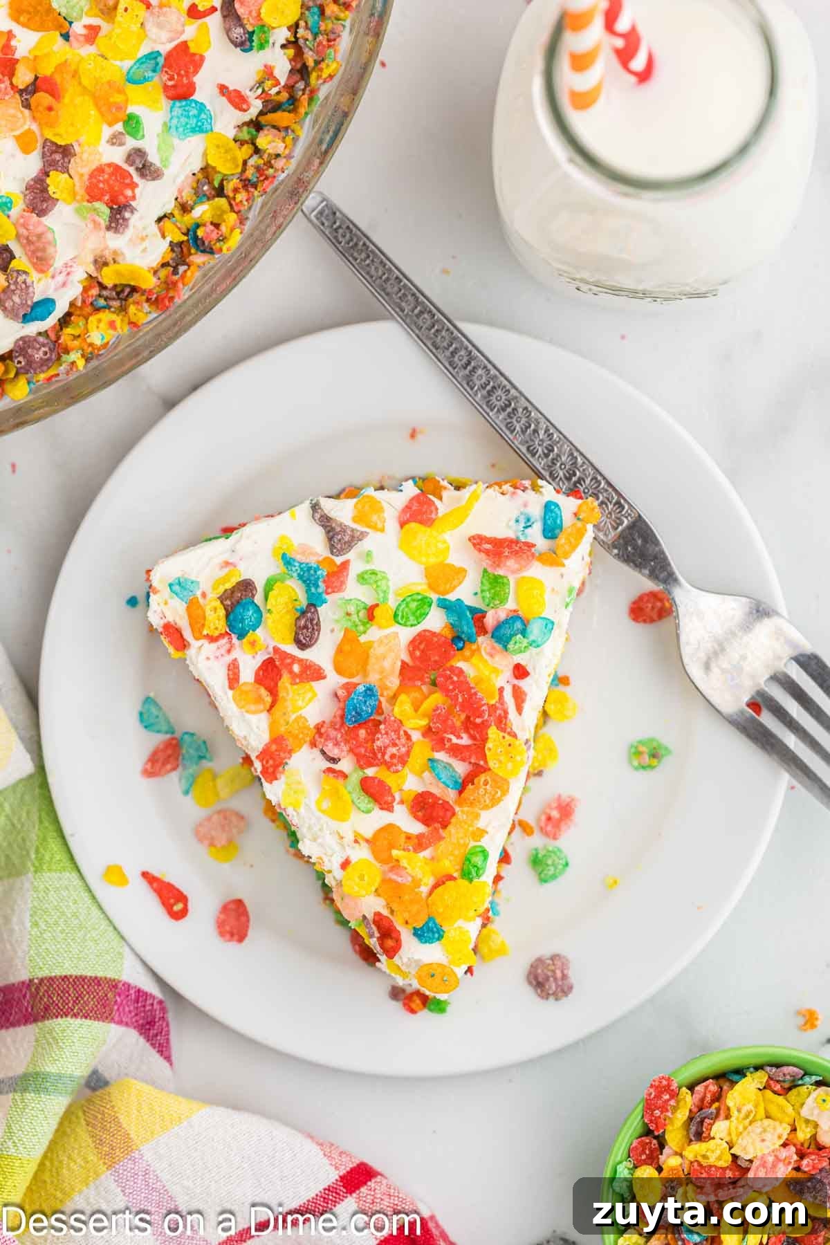 Fruity Pebbles Cheesecake Recipe with Rainbow Cereal Topping 10 Slice of Fruity Pebbles Cheesecake on plate.