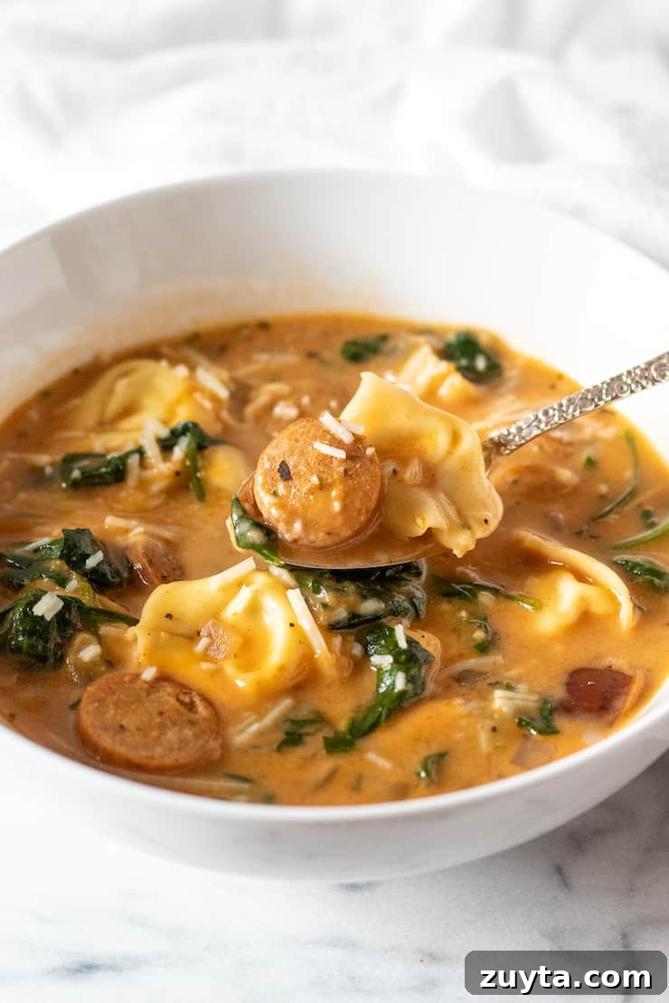 Creamy Cajun Tortellini Soup Recipe 10 Creamy Cajun soup with tortellini and sausage on spoon.