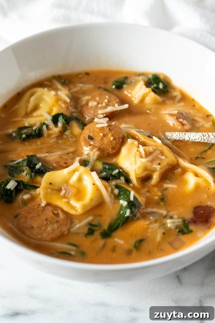 Creamy Cajun Tortellini Soup Recipe 2 Bowl of Cajun tortellini soup with spoon.