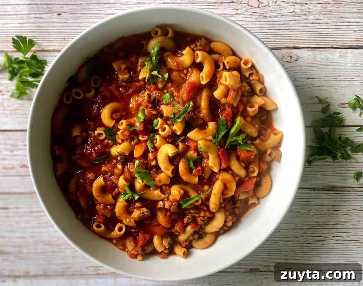 Hearty Vegan Goulash Recipe: Hungarian-Style Stew 6 Vegan goulash in a bowl on the counter with parsley garnish.