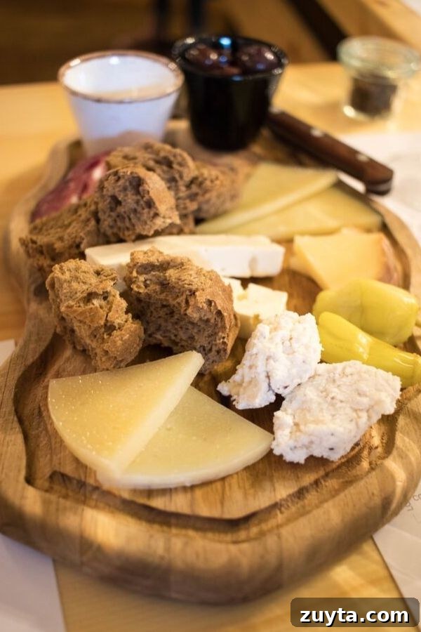 Athens Wine Tasting Tour 4 Selection of Greek cheeses, cold cuts and olives with bread on a wooden cutting board